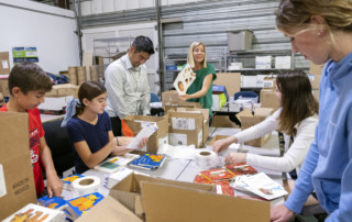 A group of volunteers work to repackage board books for distribution to local hospitals as part of the Books for Babies program.