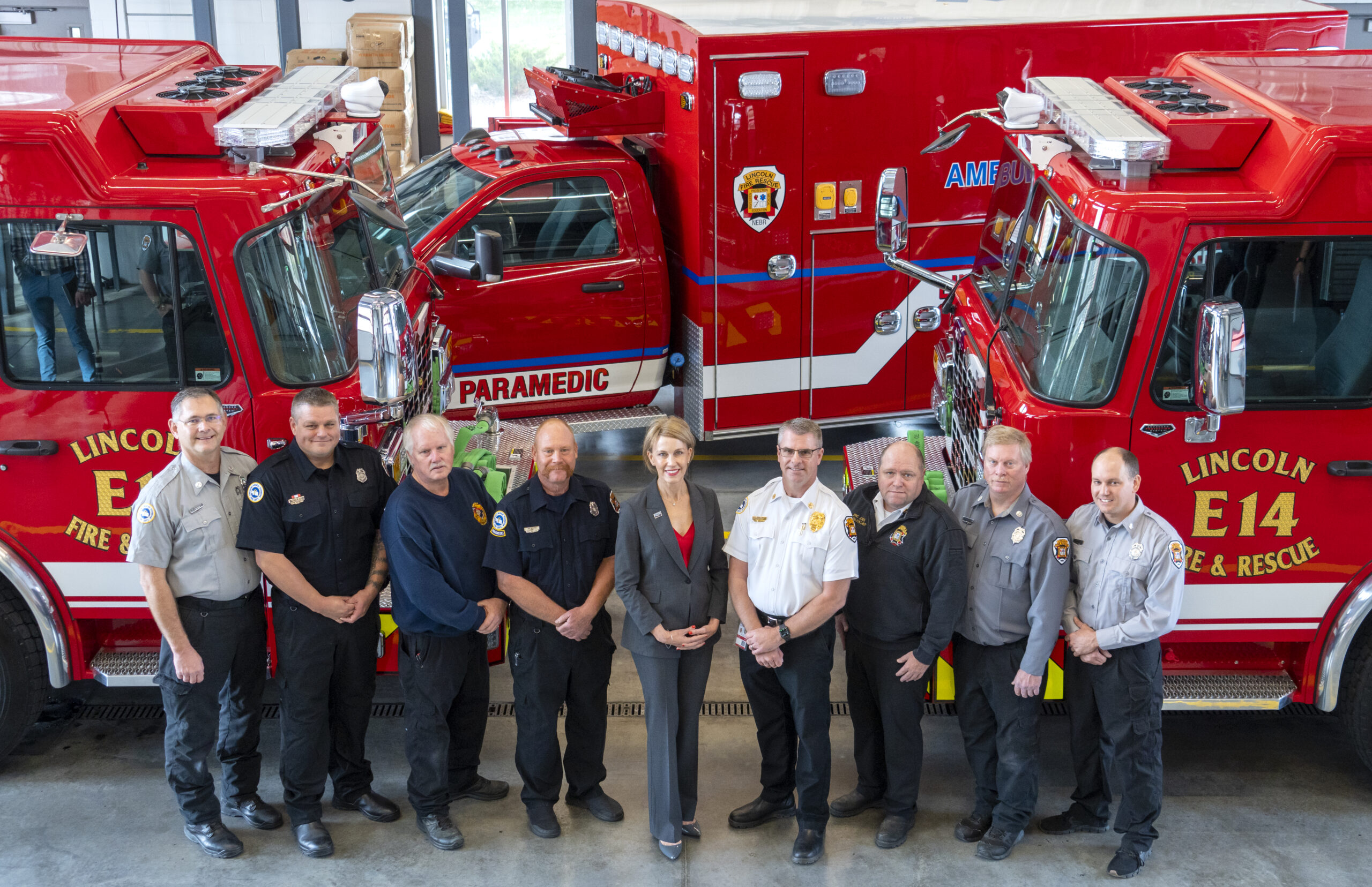 Lincoln Fire and Rescue standing with their new fire fighting trucks and ambulance.